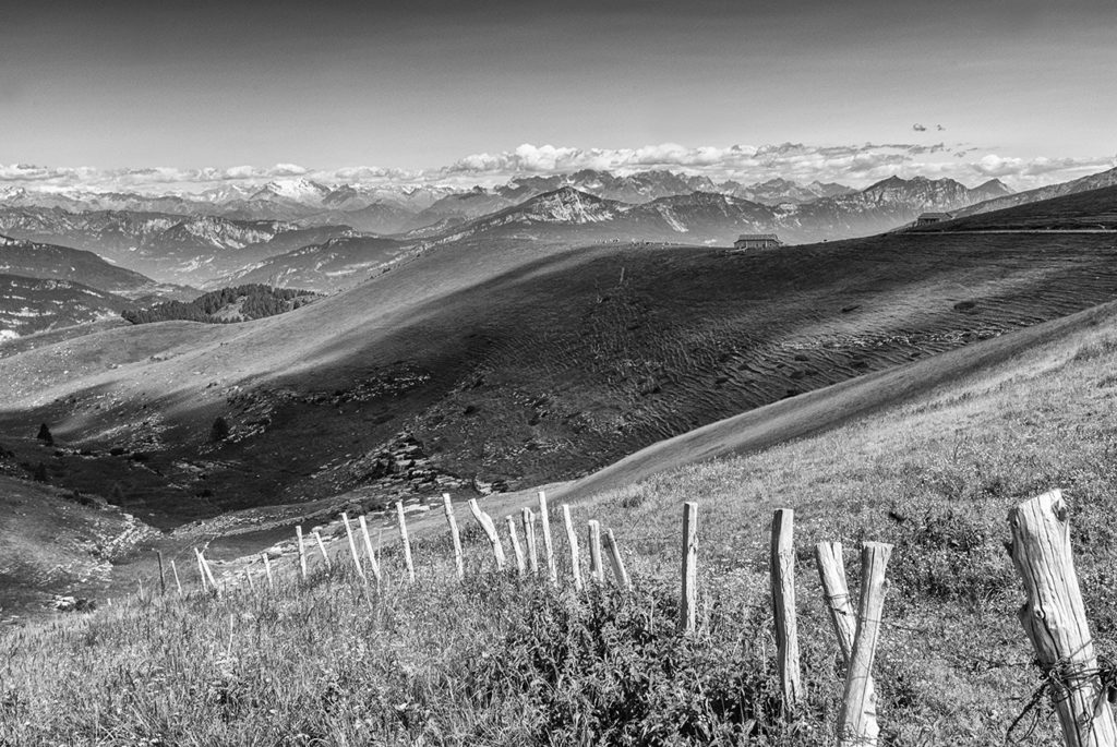 Lessinia, dolci pendii, sullo sfondo le montagne dell'Adamello-Brenta, bianco e nero